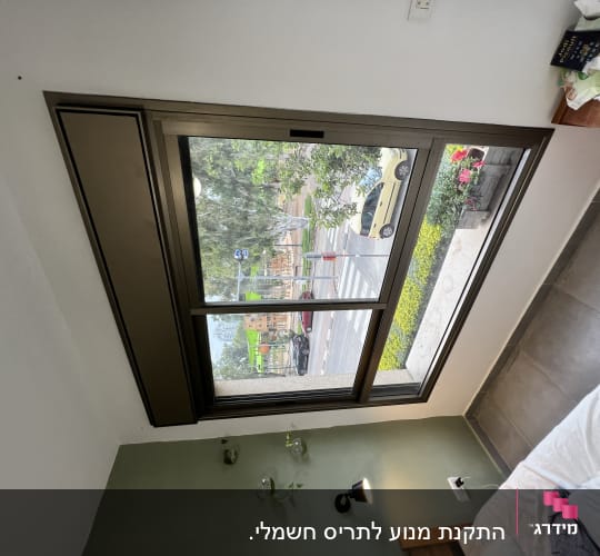חלון עם תריסים חומים סגורים בחלק העליון